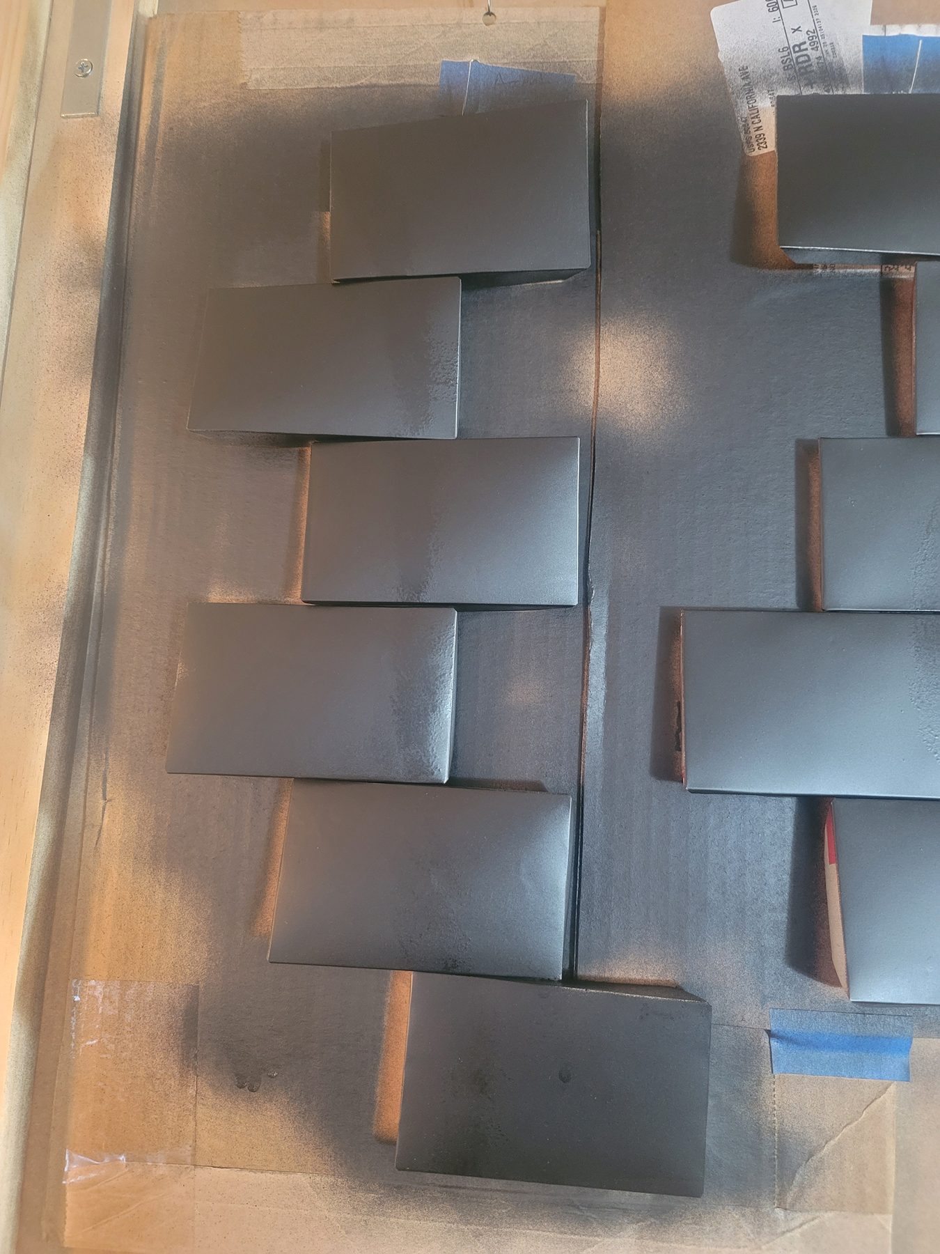 Formed aluminum tiles arranged on a board during portrait assembly