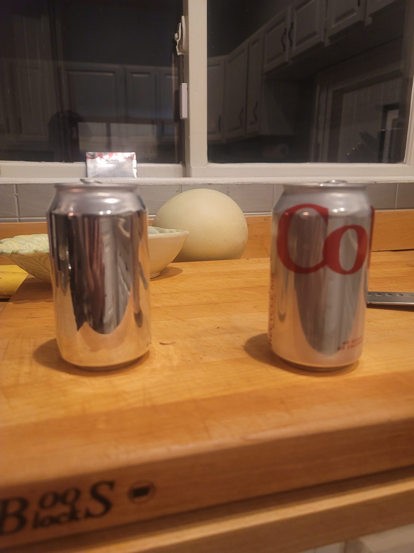 Opened aluminum can sheet standing beside another can